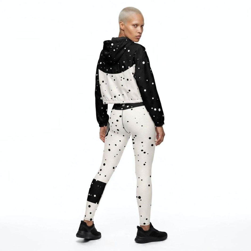 Model wearing God Approved matching activewear set consisting of a cropped windbreaker and leggings, with polka dot pattern, back view