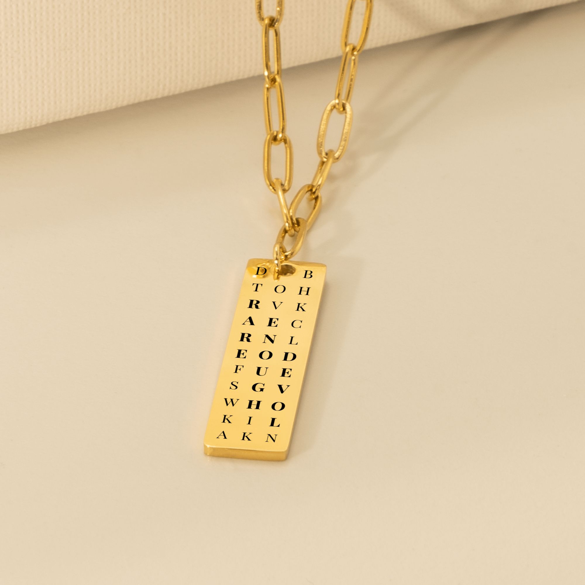 Rare enough loved gold plated paperclip chain necklace on beige background in a soft setting