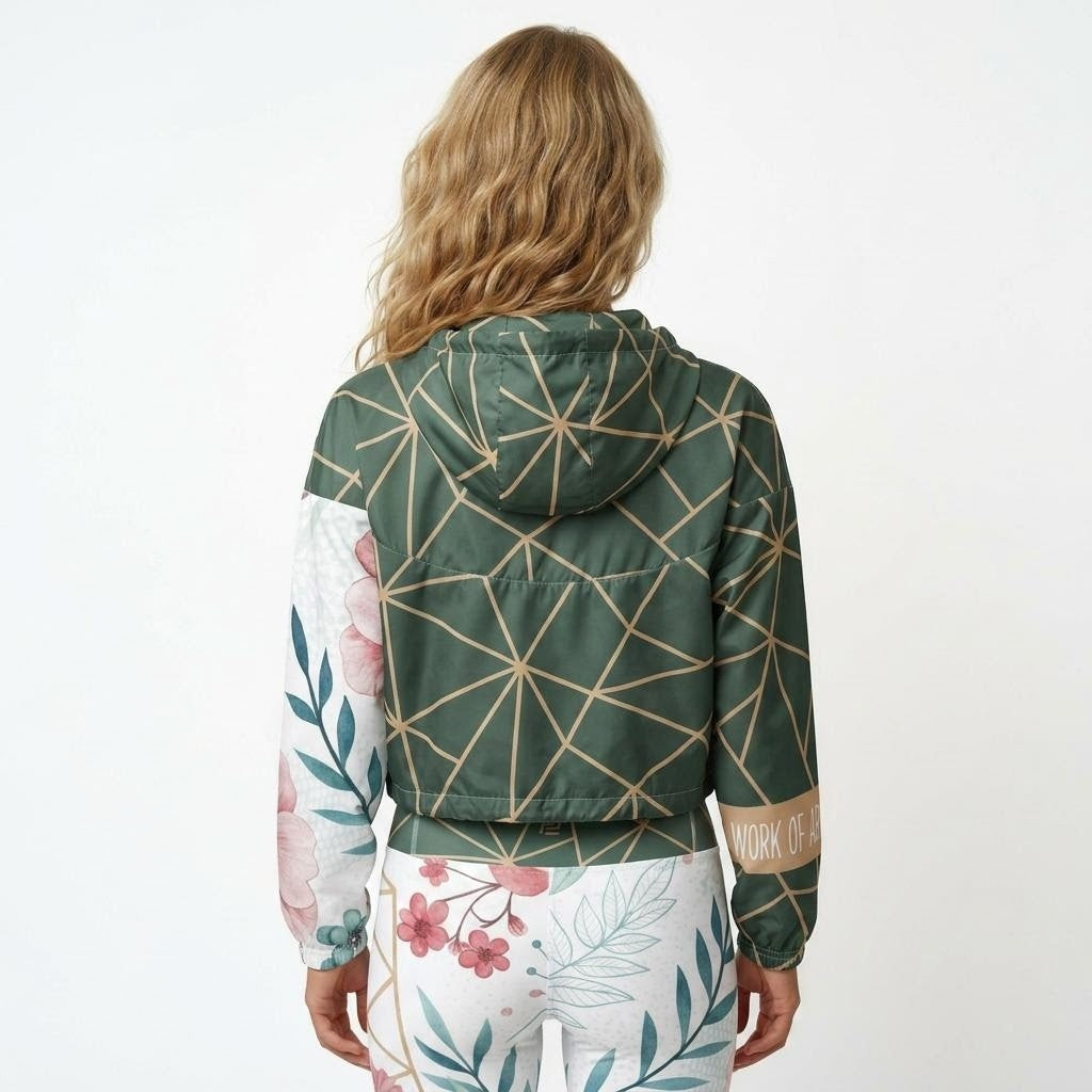 Model wearing Work of Art matching activewear set consisting of a cropped windbreaker and leggings, with floral pattern and green geometric design, back view