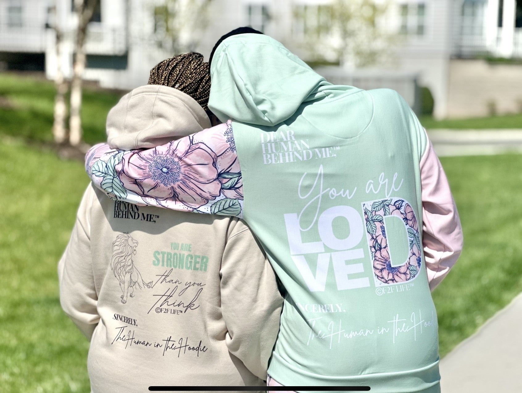 Two People hugging wearing dear human behind me hoodies 