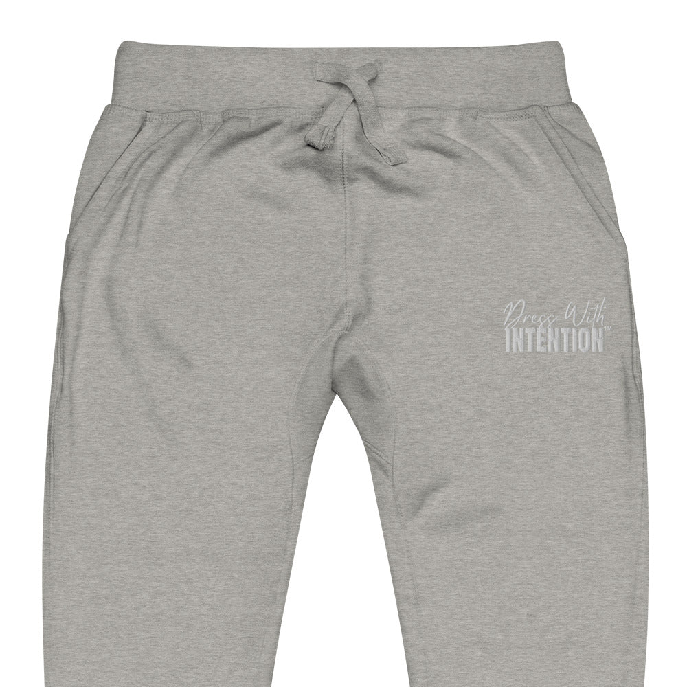 Zoomed in front view of "Dress With Intention" white writing unisex joggers in carbon grey