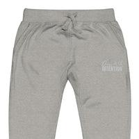 Zoomed in front view of "Dress With Intention" white writing unisex joggers in carbon grey