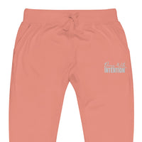 Zoomed in front view of "Dress With Intention" in white writing unisex joggers in dusty rose